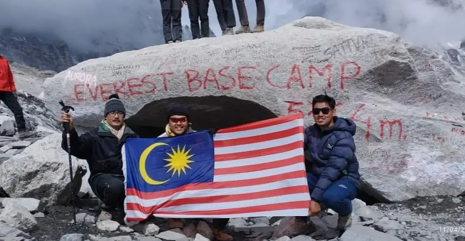 Malaysian guest of Elysian Quest taking picture at Everest Base Camp with Malaysia flag
